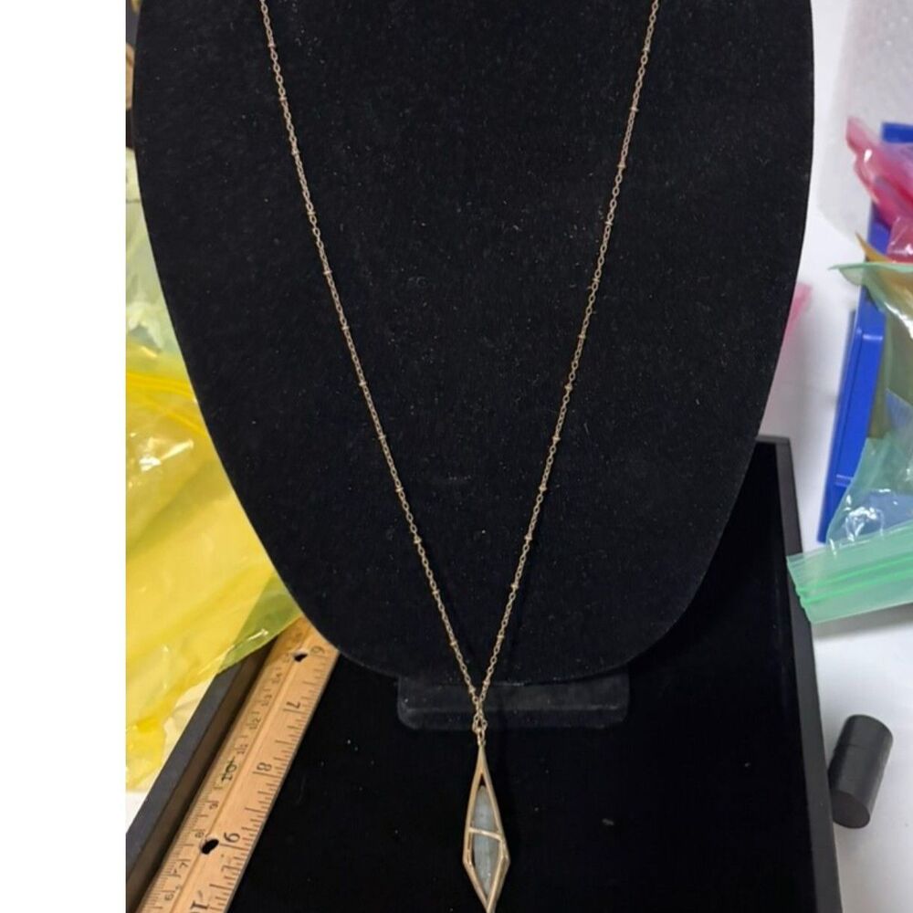 vtg long gold tone necklace with geometic diamond shaped cage holding green sto